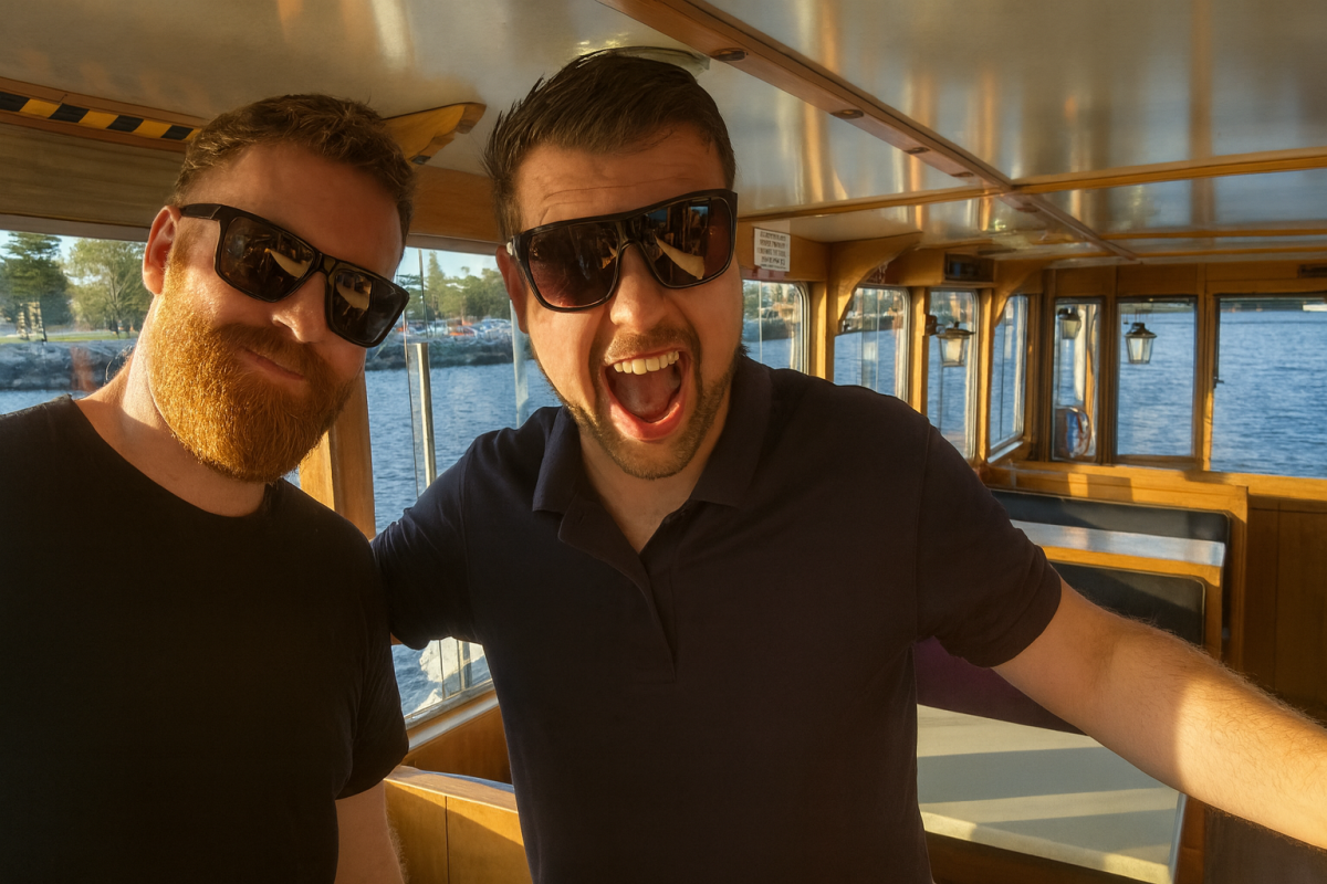 Two smiling men in black shirts and sunglasses