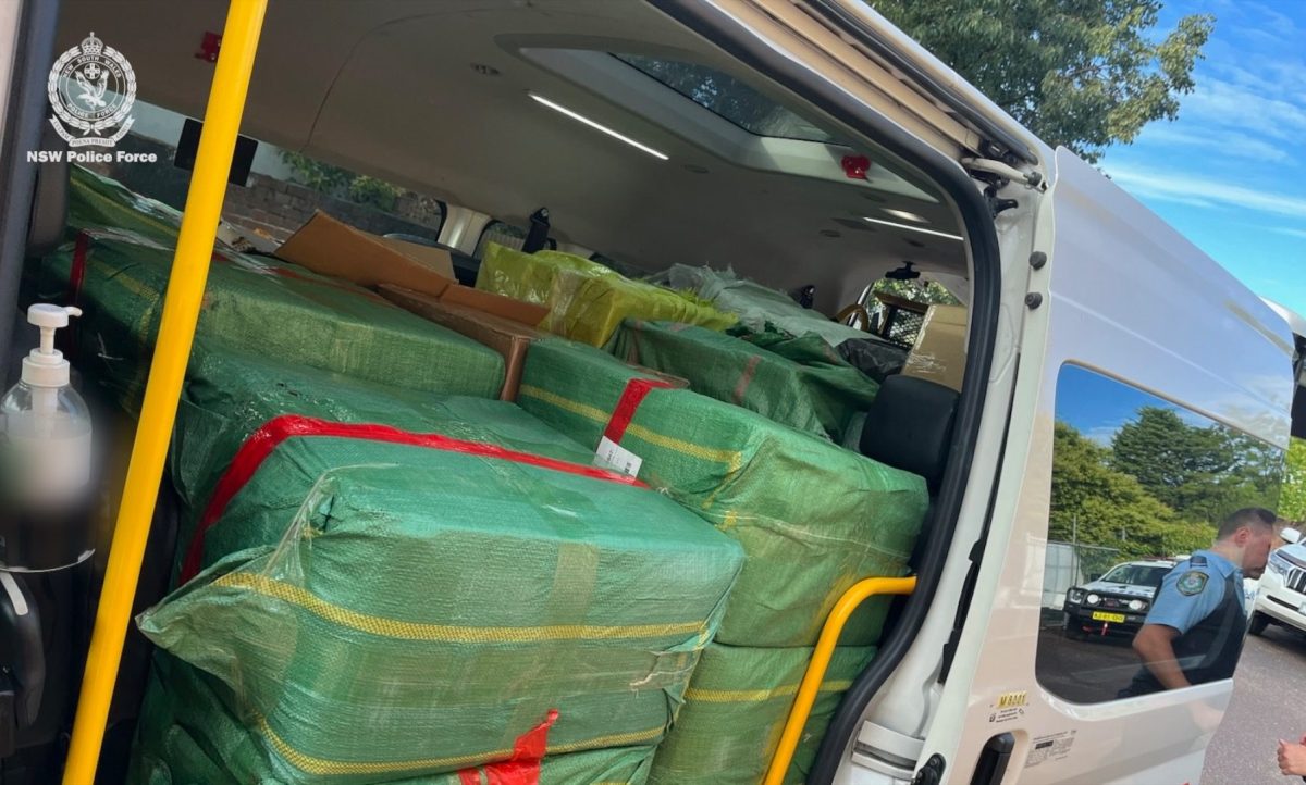 Large boxes wrapped in green tarps inside a van