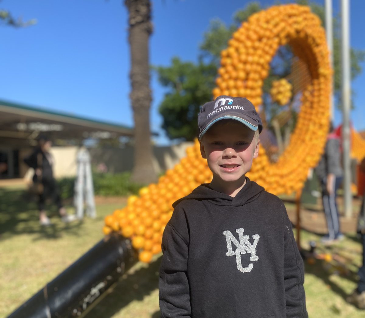Conor Meehan poses in front of giant orange sculpture